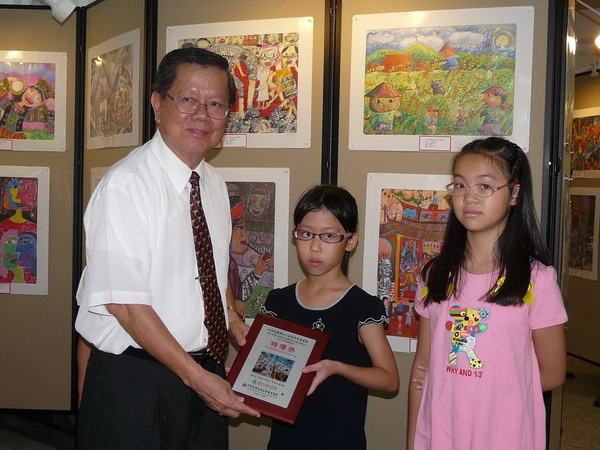 中華民國兒童美術教育學會卓英豪顧問頒發國內特優獎牌給得獎學生