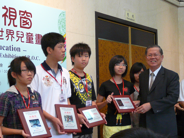中華民國兒童美術教育學會卓英豪顧問頒發國內特優獎牌給得獎學生之三